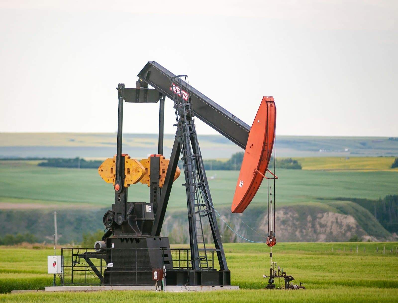 An oil pumpjack standing in open grassland.