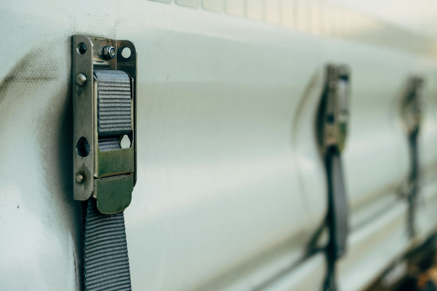 A ratchet strap buckle and webbing cinched over a load.